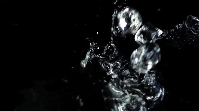 Falling of cubes of ice on a black background. Slow motion.