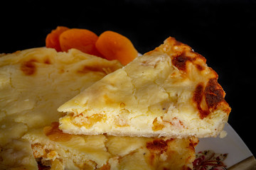 Homemade mini quiche with cheese and dried apricots isolated on black background.