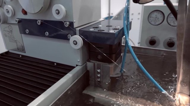Modern, technological automatic equipment for electrical discharge wire cutting the metal detail. Shot in motion