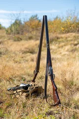 Sierkussen Twee jachtgeweer met dubbele loop staan naast elkaar midden in de natuur, retro geweer. Natuurlijk landschap. Concept van jagen, buitensporten, hobby& 39 s en levensstijl © dero2084