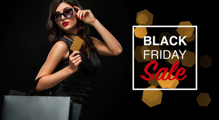 Black friday sale concept. Shopping woman holding grey bag isolated on dark background in holiday