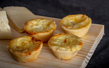 Homemade mini quiche with cheese on rustic background.