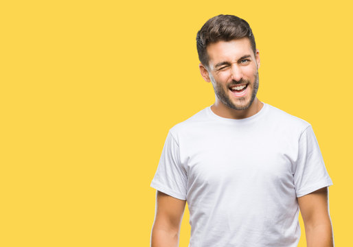 Young handsome man over isolated background winking looking at the camera with sexy expression, cheerful and happy face.