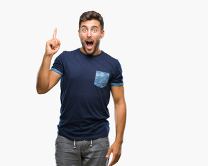 Naklejka premium Young handsome man over isolated background pointing finger up with successful idea. Exited and happy. Number one.