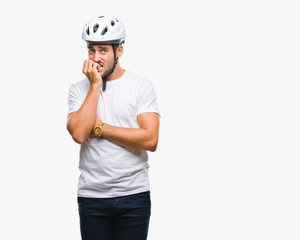 Young handsome man wearing cyclist safety helmet over isolated background looking stressed and nervous with hands on mouth biting nails. Anxiety problem.