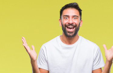 Adult hispanic man over isolated background celebrating crazy and amazed for success with arms raised and open eyes screaming excited. Winner concept