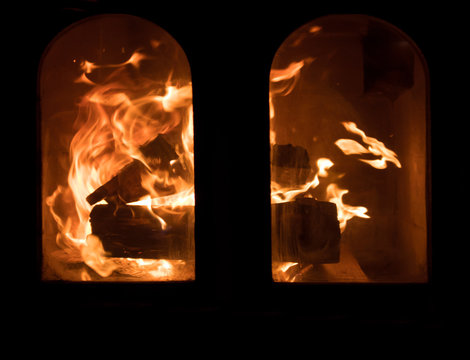 Raging forks of flame in fireplace behind the protective glass screen