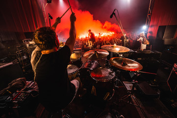 Obraz premium Perkusista na scenie. sylwetka zespołu muzycznego w akcji na scenie muzycznej. na scenie występuje popularny zespół rockowy.