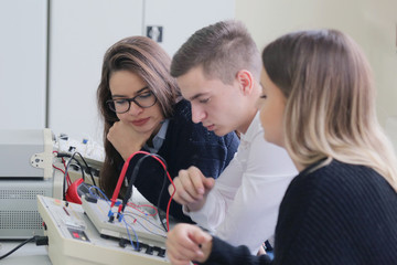 Three young students in technical vocational training, the lesson in technical college.