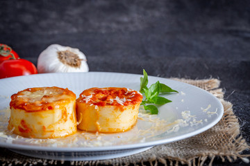 Italian rondelli with pomodoro sauce and cheese on rustic background.