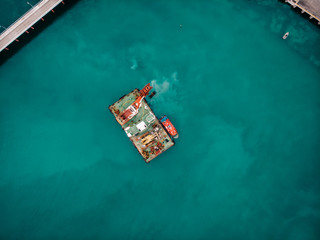 Fototapeta na wymiar Offshore industrial platform or tower with crane or science sea research center, top or aerial view