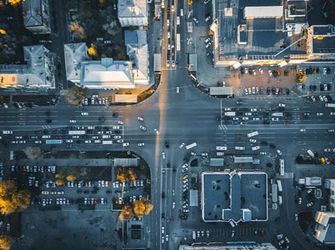 Road traffic on crossroad or intersection downtown of European city, aerial or top view
