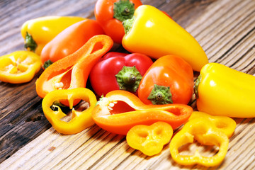 Fresh red, yellow and orange bell pepper on wooden background. raw vegetable.