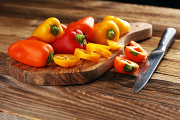 Fresh red, yellow and orange bell pepper on wooden background. raw vegetable.