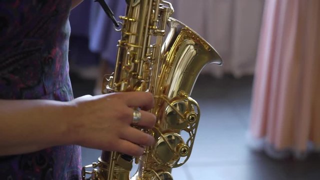 Saxophonist woman playing sax at the party