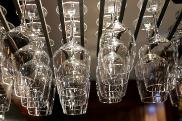 Empty wine glasses hanging above the bar counter