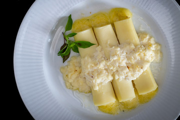 Italian caneloni with bechamel sauce and cheese on rustic background.