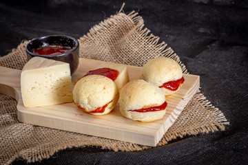 Brazilian homemade cheese bread AKA 'pao de queijo’, stuffed with guava dessert, on a rustic background.