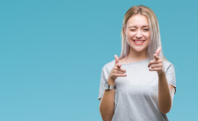 Young blonde woman over isolated background pointing fingers to camera with happy and funny face....