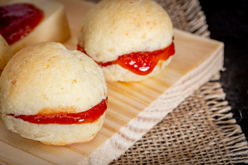 Brazilian homemade cheese bread AKA 'pao de queijo’, stuffed with guava dessert, on a rustic background.