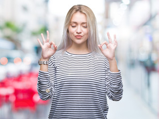 Young blonde woman over isolated background relax and smiling with eyes closed doing meditation gesture with fingers. Yoga concept.