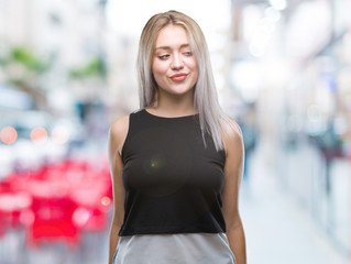 Fototapeta na wymiar Young blonde woman over isolated background looking away to side with smile on face, natural expression. Laughing confident.