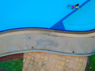 Swimming pool blue color clear water and people enjoying in summer sunny day and top view angle.