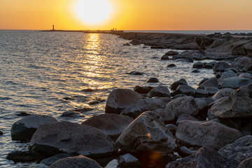 breakwater in the sea with red lighthouse at the end