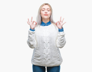 Fototapeta na wymiar Young blonde woman wearing winter sweater over isolated background relax and smiling with eyes closed doing meditation gesture with fingers. Yoga concept.