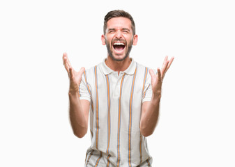 Naklejka premium Young handsome man over isolated background celebrating mad and crazy for success with arms raised and closed eyes screaming excited. Winner concept
