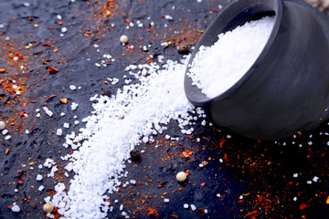 Red spices, salt and pepper on black marble. Black abstract background. Top view.