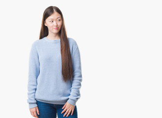 Young Chinese woman over isolated background smiling looking side and staring away thinking.