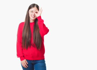 Young Chinese woman over isolated background wearing glasses doing ok gesture with hand smiling, eye looking through fingers with happy face.
