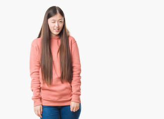Young Chinese woman over isolated background wearing sport sweathshirt winking looking at the camera with sexy expression, cheerful and happy face.