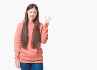 Young Chinese woman over isolated background wearing sport sweathshirt showing and pointing up with fingers number three while smiling confident and happy.