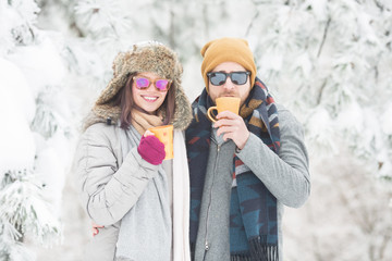 Young couple drinking coffee in winter outdoors