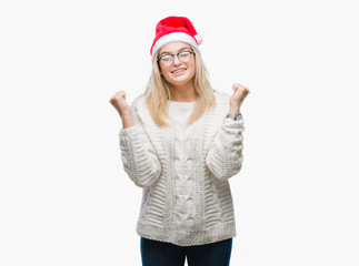 Young caucasian woman wearing christmas hat over isolated background celebrating surprised and amazed for success with arms raised and open eyes. Winner concept.
