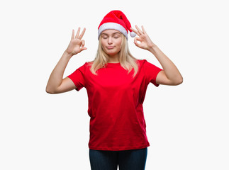 Young caucasian woman wearing christmas hat over isolated background relax and smiling with eyes closed doing meditation gesture with fingers. Yoga concept.