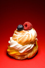 Cake with biscuit and berries and sprinkle on a substrate on a colored background.