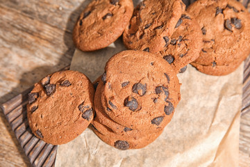 Board with chocolate chip cookies on wooden table
