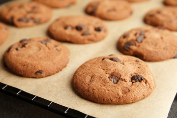Tasty chocolate chip cookies on parchment, closeup