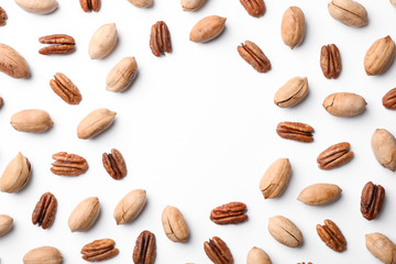 Frame made of pecan nuts on white background, top view with space for text