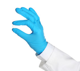 Doctor in medical glove holding pill on white background