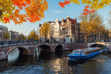 Traditional old houses on canal at fall day in Amsterdam, Netherlands at autumn season.