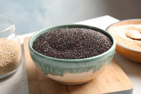 Bowl with raw black quinoa on table