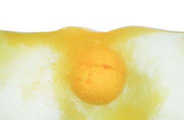 Bath bomb in water on white background