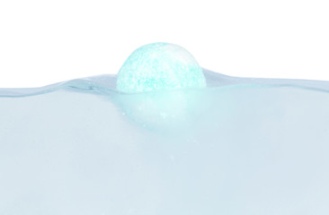 Bath bomb in water on white background