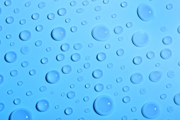 Water drops on color background, top view