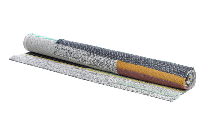 Rolled colorful carpet on white background. Interior element