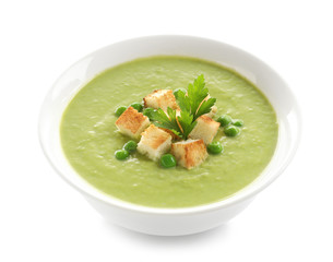 Fresh vegetable detox soup made of green peas with croutons in dish on white background